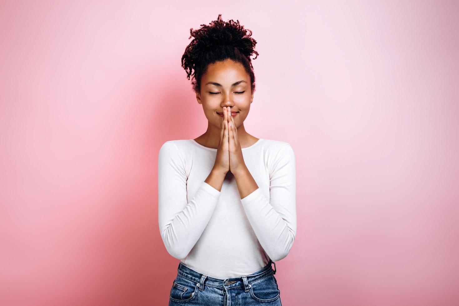 Happy young girl praying with her eyes closed photo