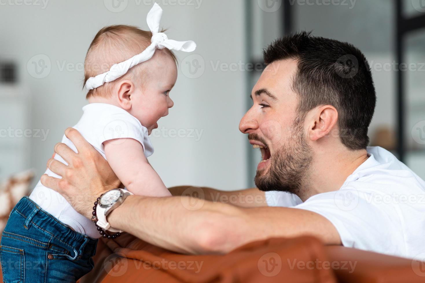 un padre feliz se divierte con su pequeña hija foto
