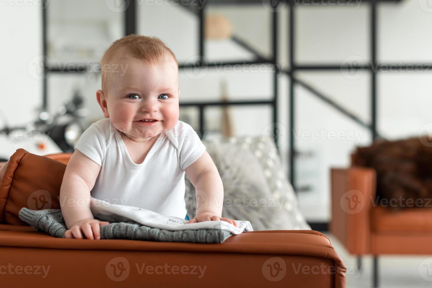 Beautiful, cute, little girl standing on the couch sincerely rejoices photo