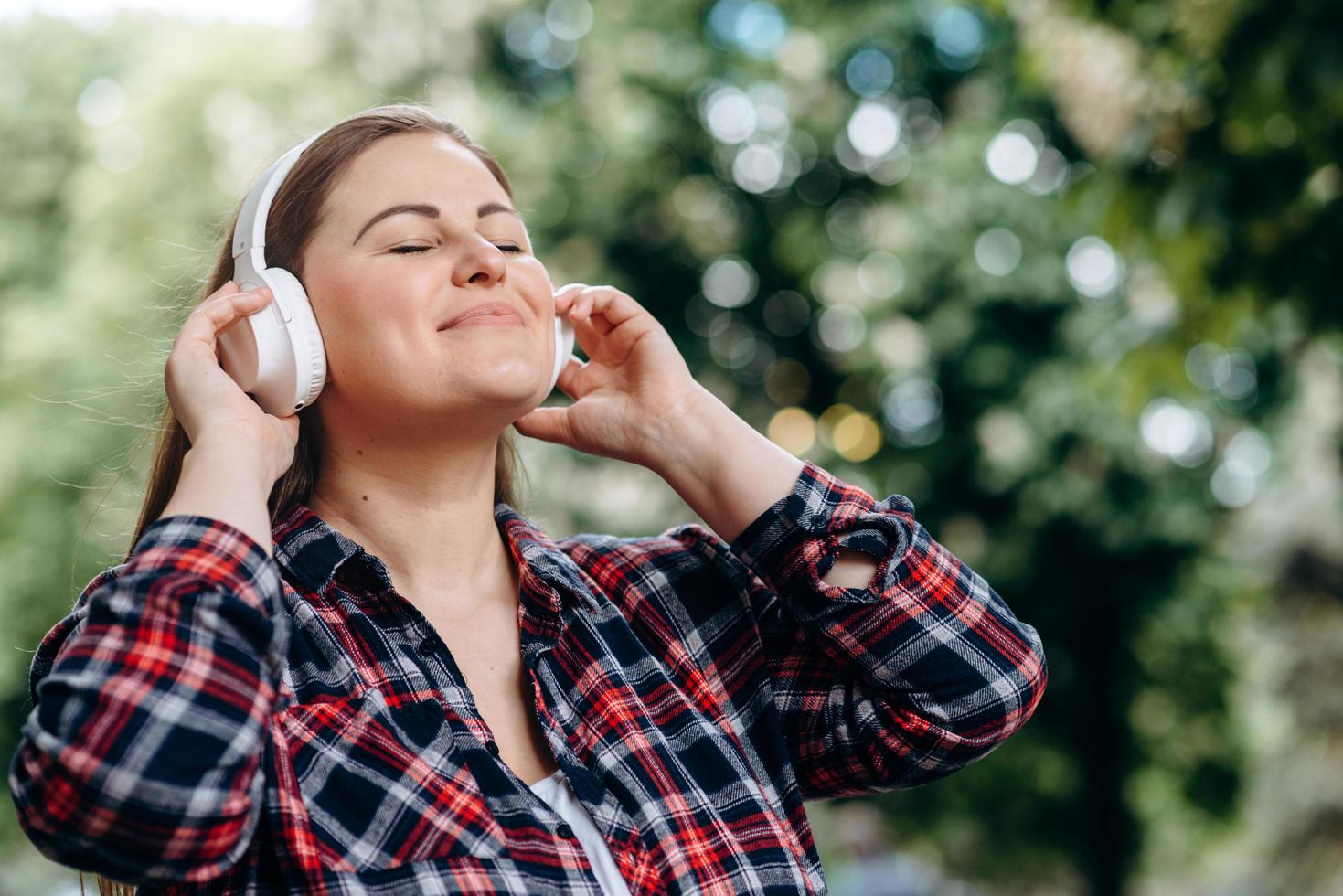 Happy girl enjoys the music coming from the headphones. photo