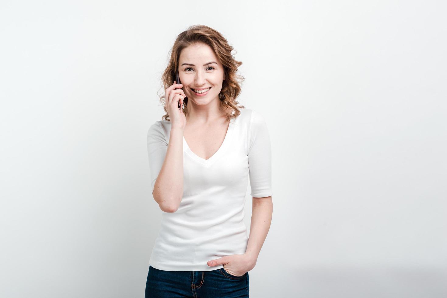 Beautiful woman talking on mobile phone and smiling, isolated on white background photo