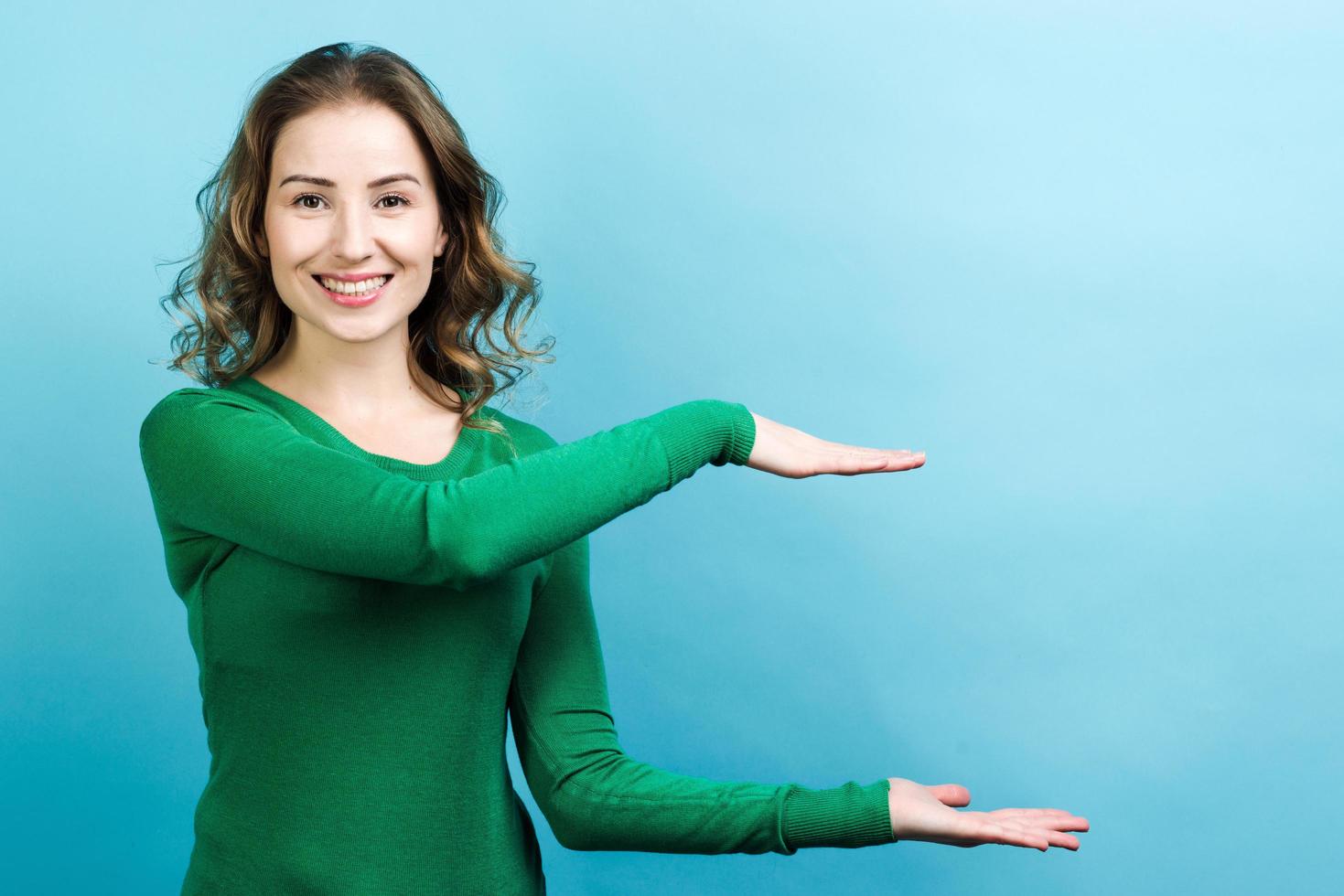 mujer sonriente sosteniendo un objeto virtual en sus manos foto