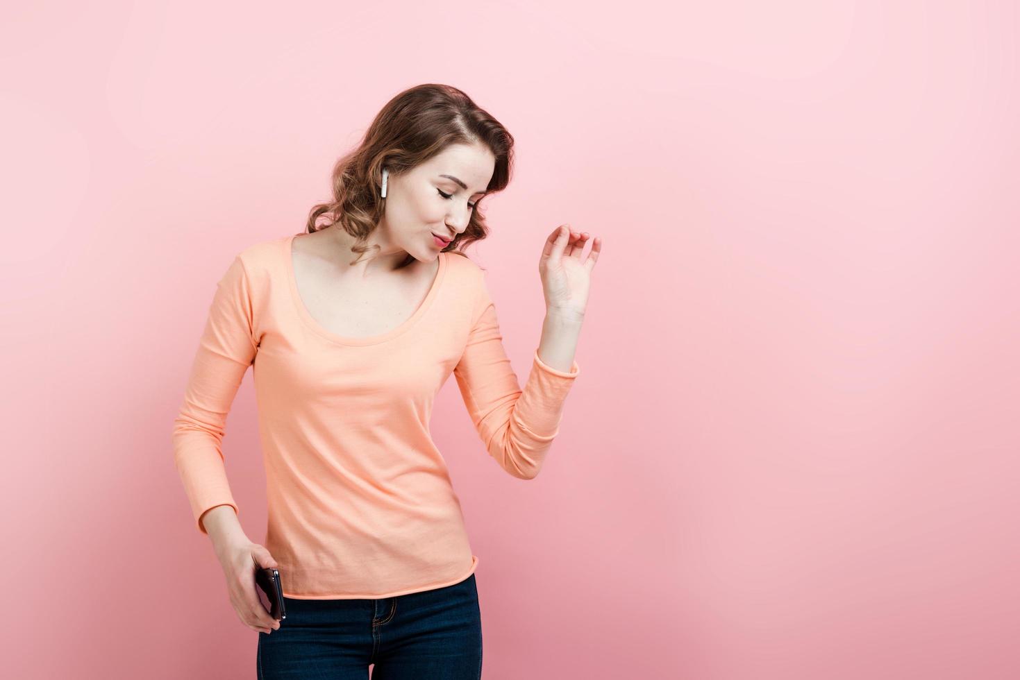 Girl in headphones with phone dancing. The profile view. photo