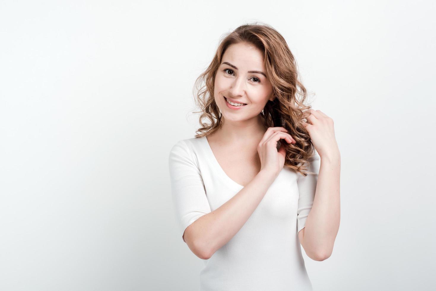 Girl posing straightens her hair. isolated on a white background. photo