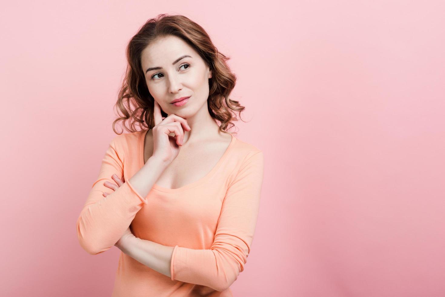 Girl thinking looking away, holding her hand near her face. photo