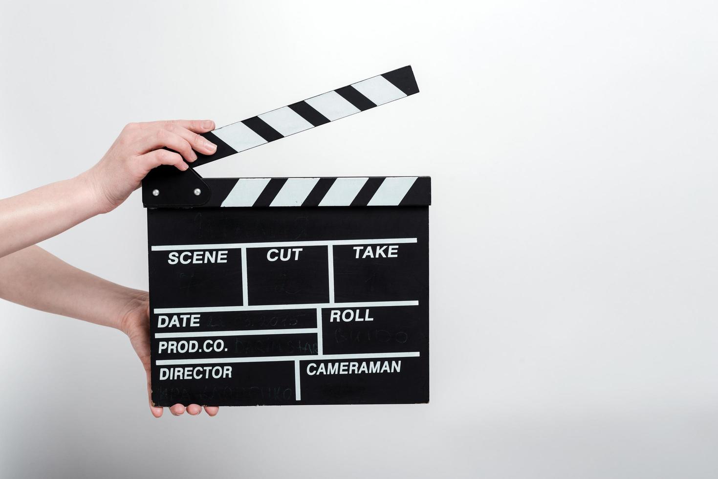 Movie production clapper board in the female hands against a white background photo