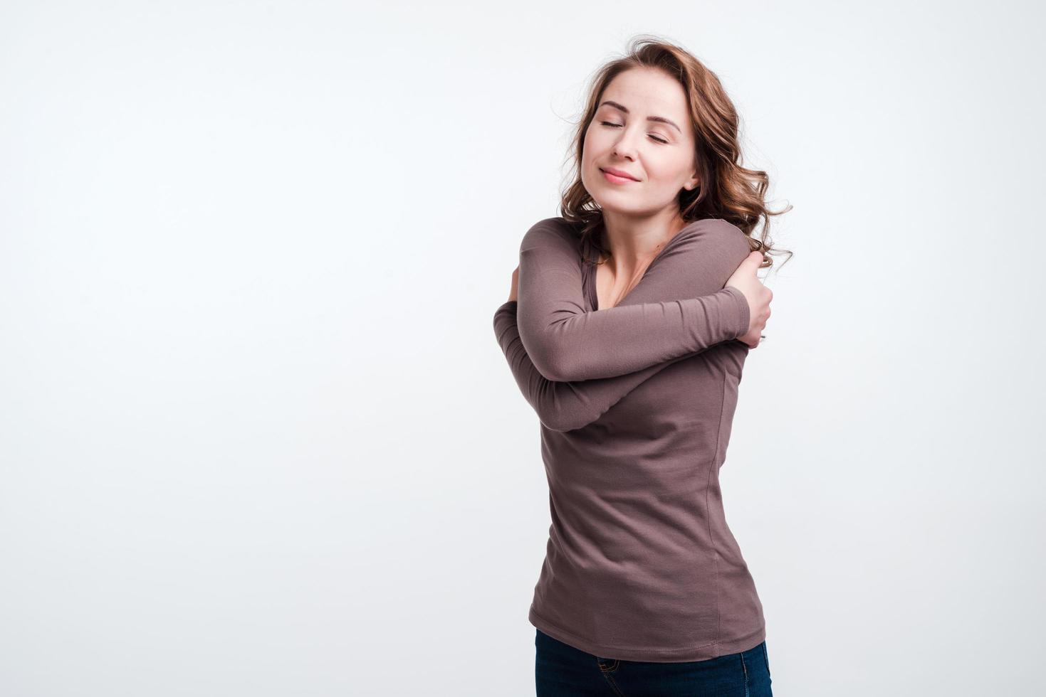 mujer bonita abrazándose a sí misma. imagen del concepto de tranquilidad y cuidado foto