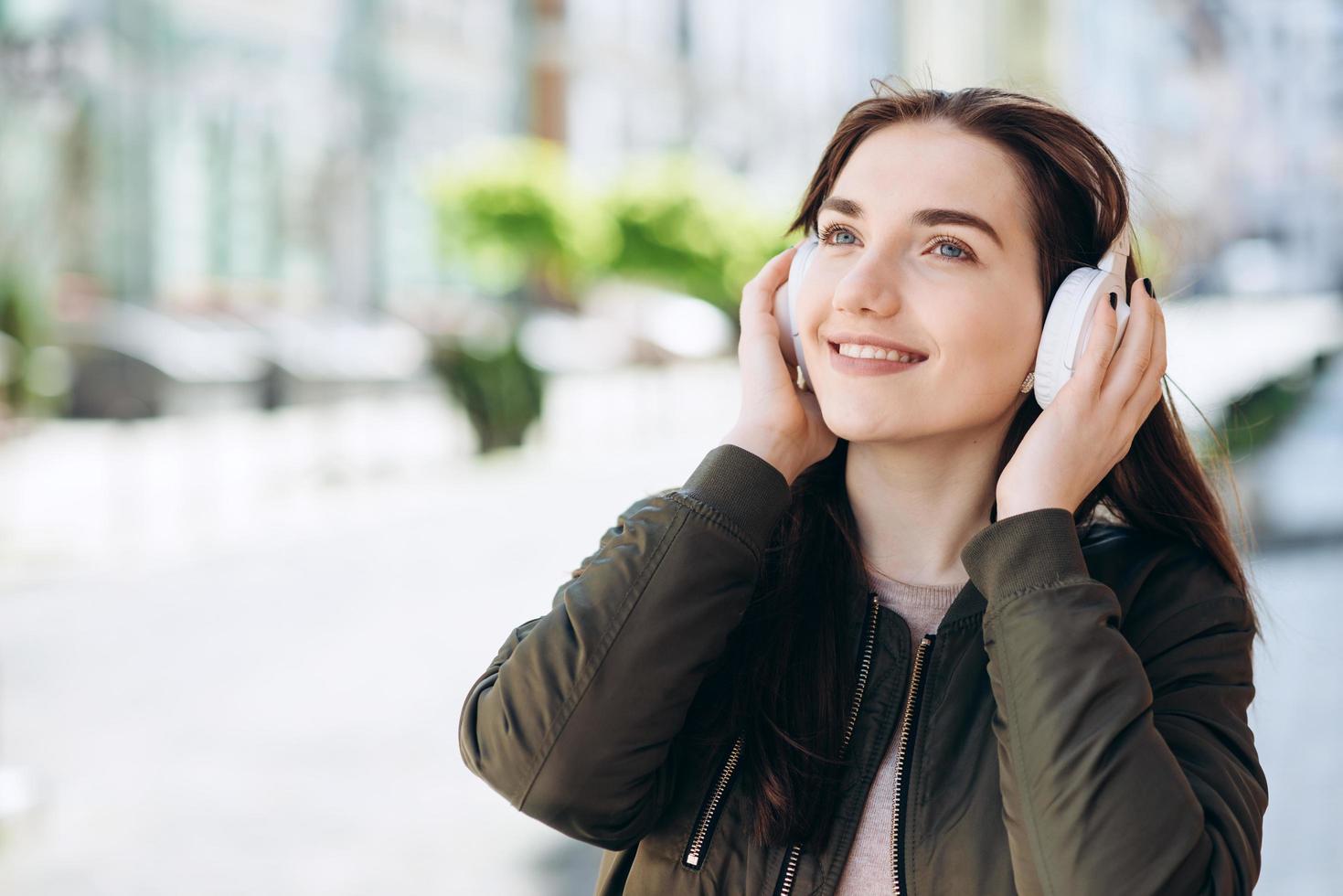 hermosa, sonriente, mujer joven - feliz, divertida caminando por las calles de la ciudad foto