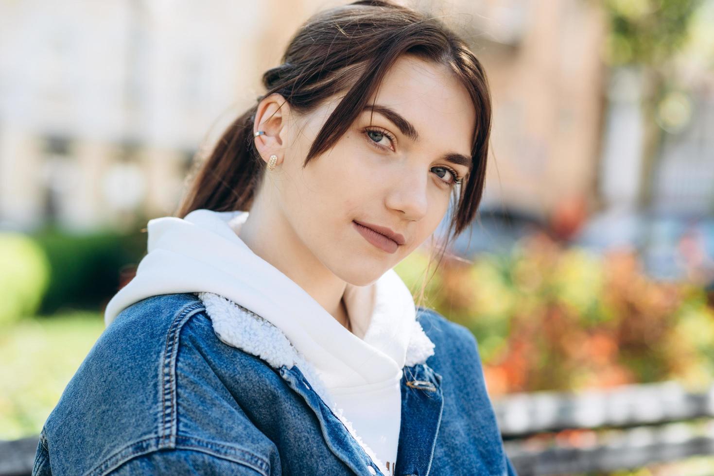 Cute, young girl looking at the camera, outdoors photo