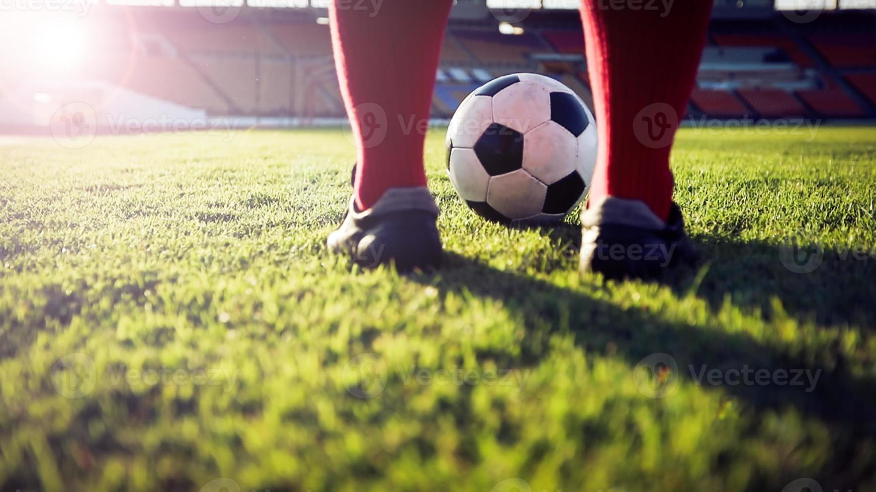 fútbol o jugador de fútbol de pie con la pelota en el campo para patear la pelota de fútbol en el estadio de fútbol foto