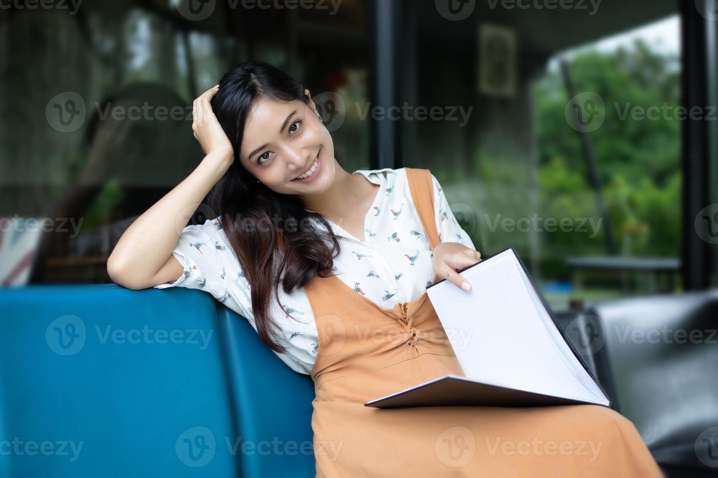 Asian women reading and smiling and happy Relaxing in a coffee shop after working in a successful office. photo