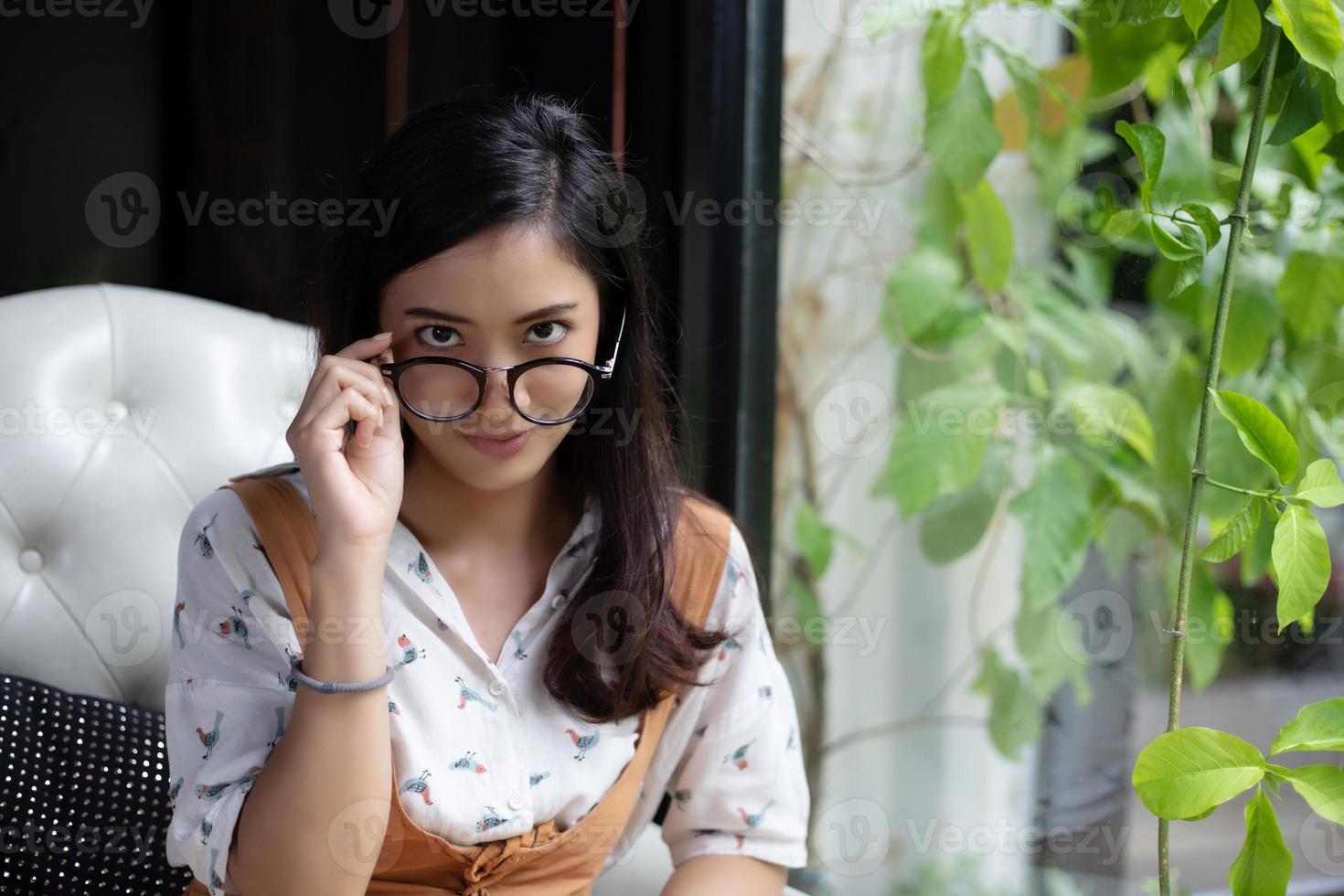 Las mujeres asiáticas están sosteniendo vasos y sonriendo en una cafetería durante las vacaciones. foto