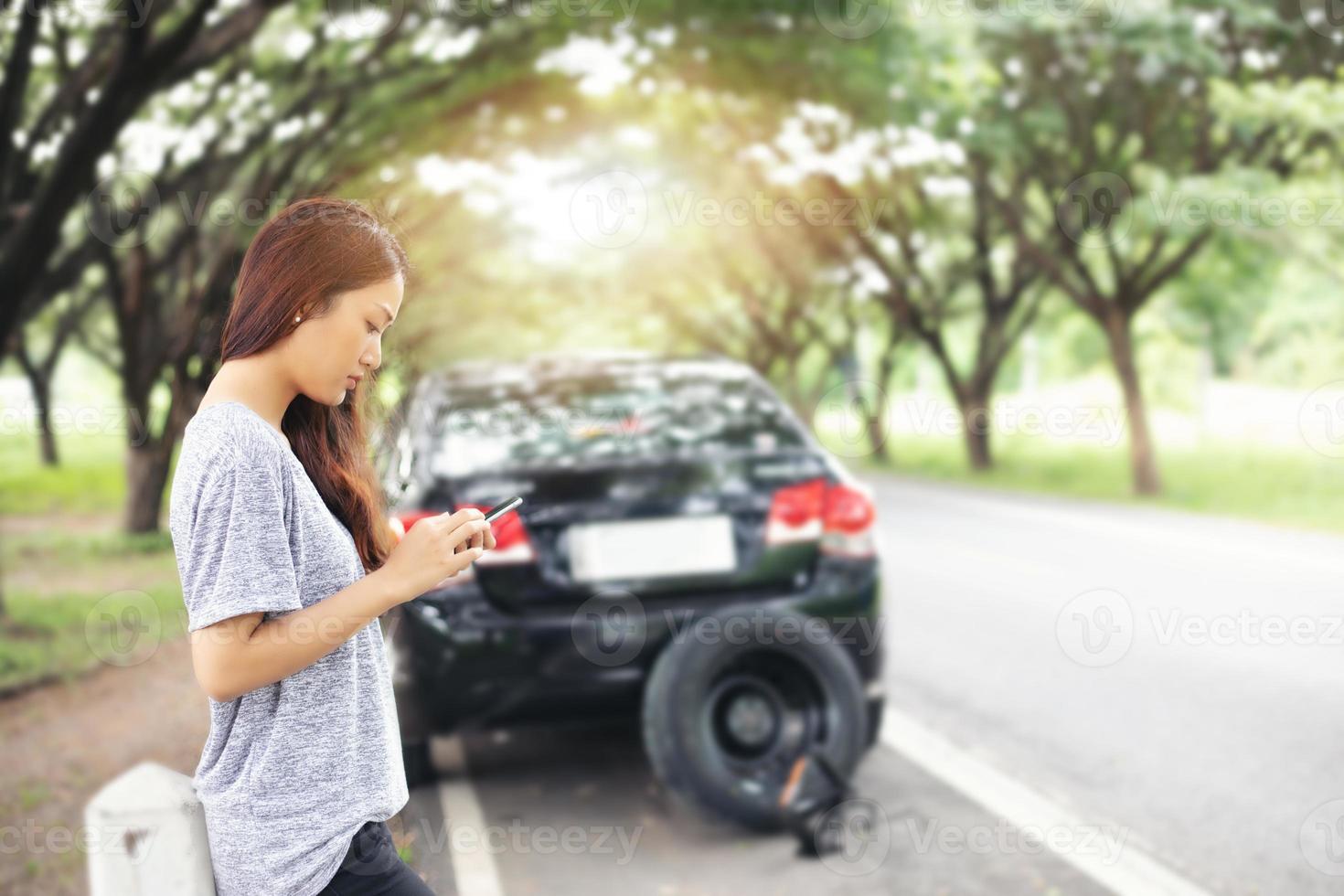 Asian woman using mobile phone while looking and Stressed man sitting after a car breakdown on street photo