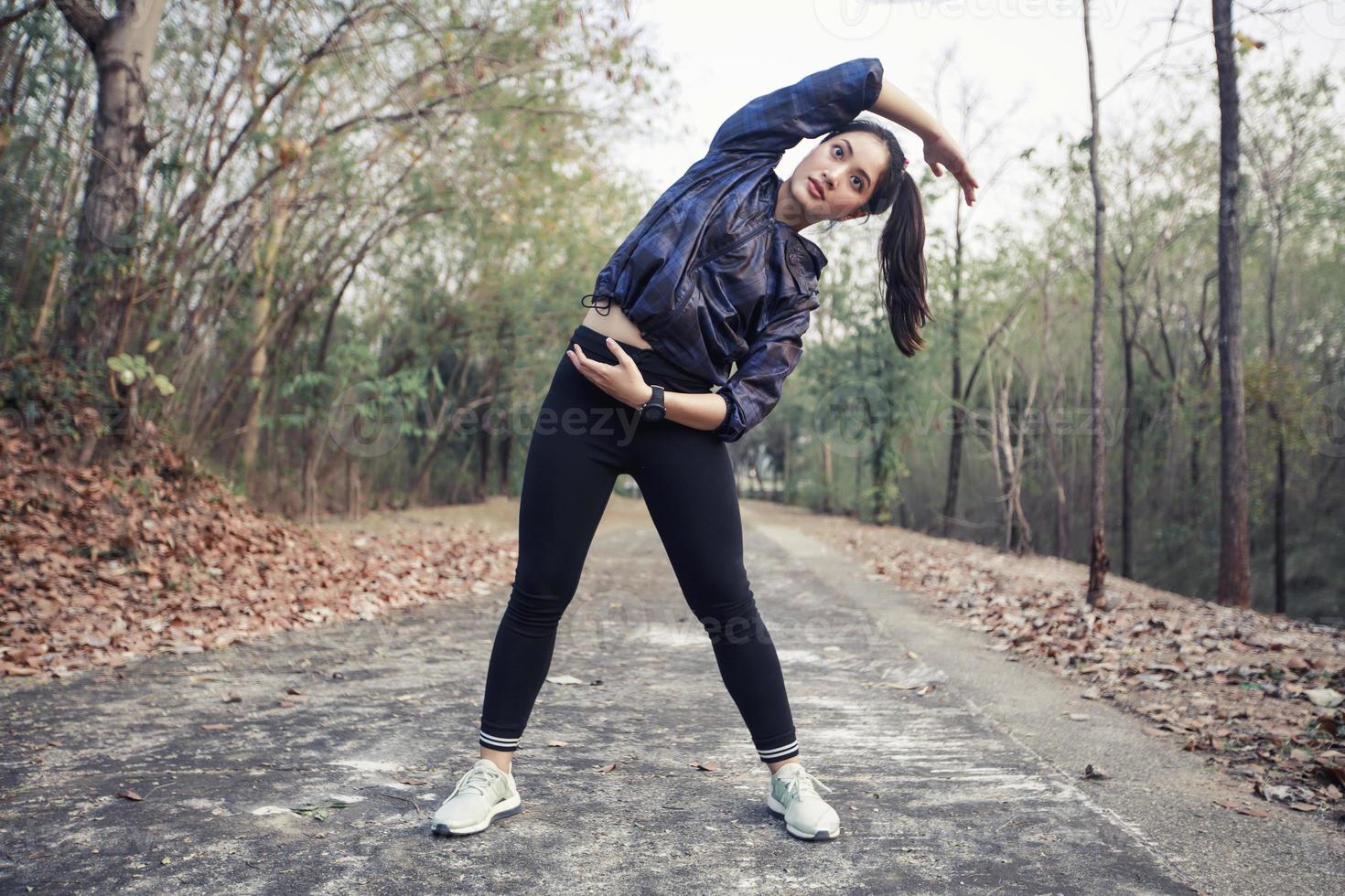 Athletic woman asia warming up and Young female athlete exercising and stretching in a park before Runner outdoors, healthy lifestyle concept. photo