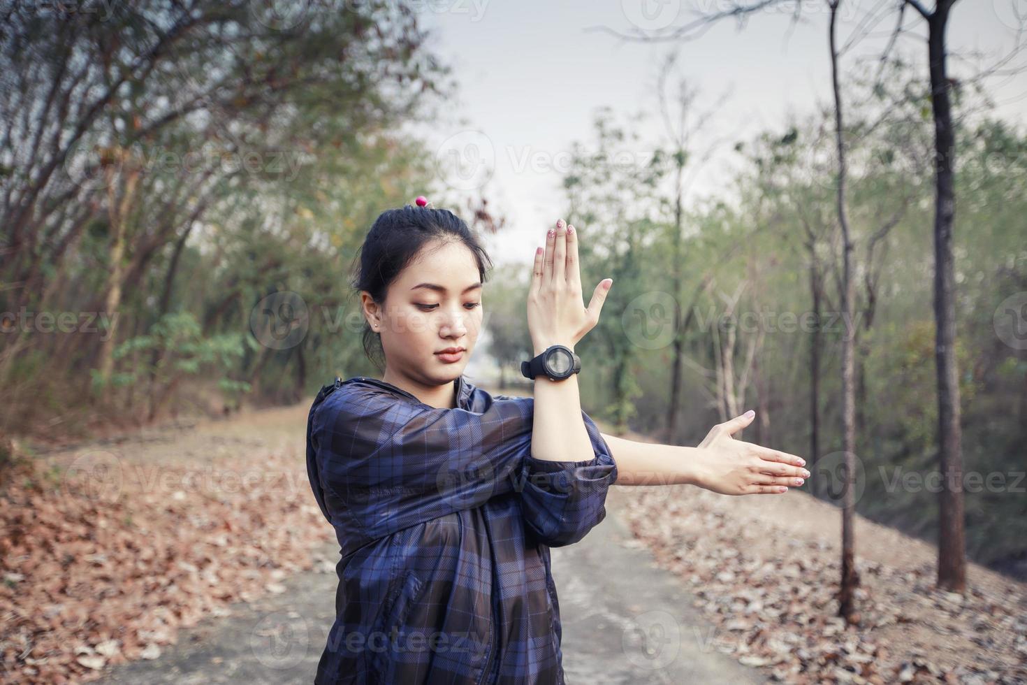 Athletic woman asia warming up and Young female athlete exercising and stretching in a park before Runner outdoors, healthy lifestyle concept. photo