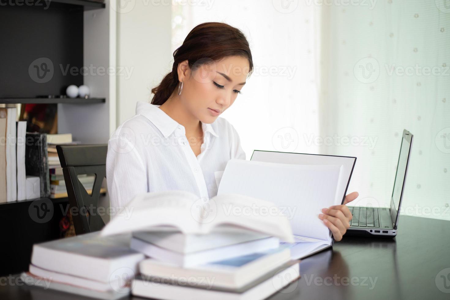 estudiante de mujeres asiáticas sonriendo y leyendo un libro para la relajación y el examen final foto