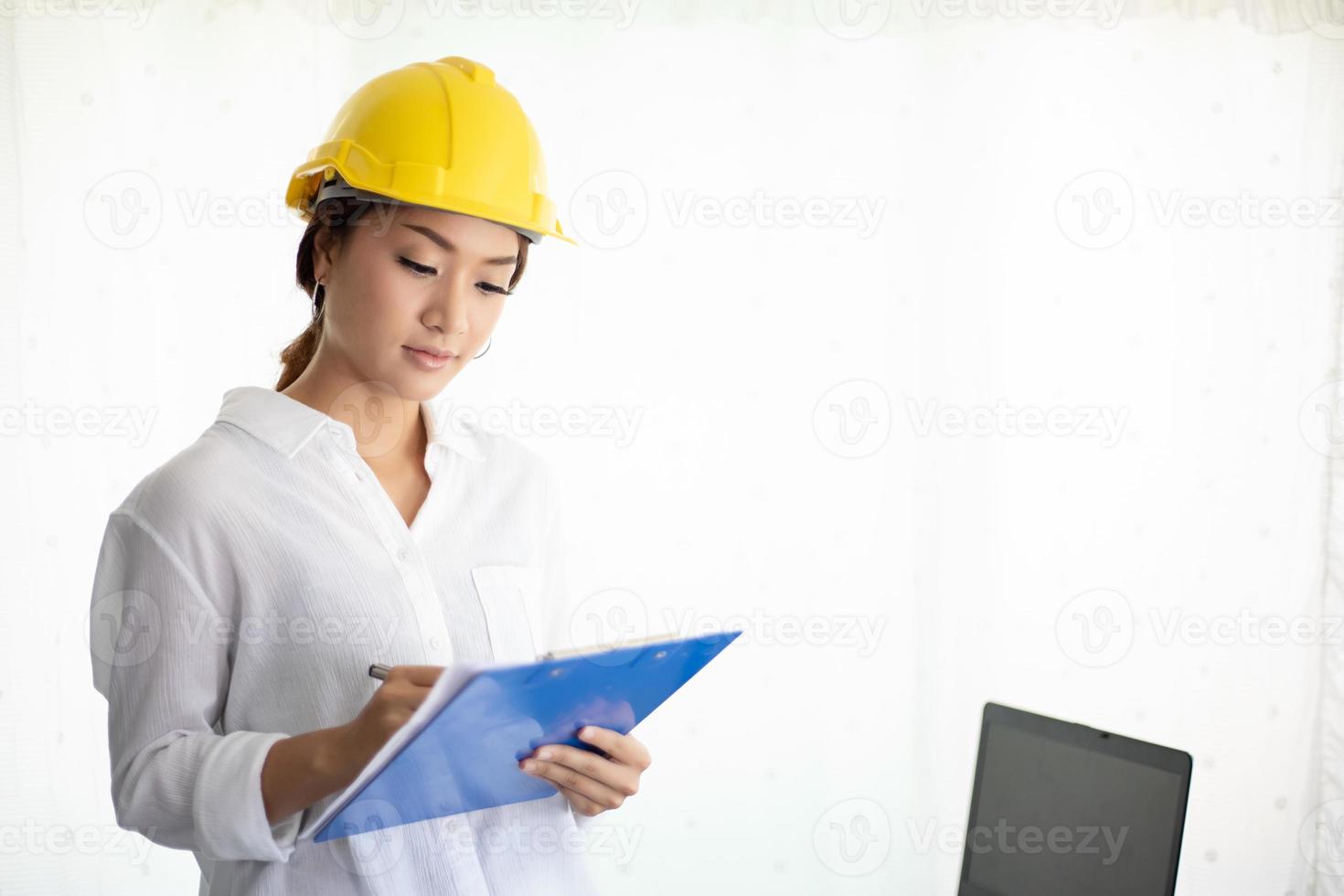 Asian women engineering inspecting and working and holding blueprints at office photo