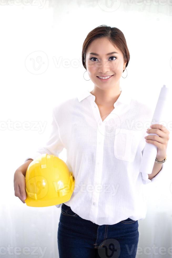 Mujeres asiáticas de ingeniería inspeccionando y trabajando y sosteniendo planos en la oficina foto