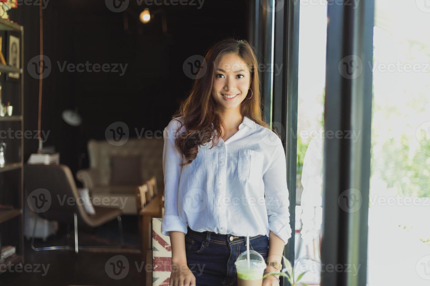 mujeres asiáticas de pie sonriendo y feliz relajándose en una cafetería después de trabajar en una oficina exitosa. foto