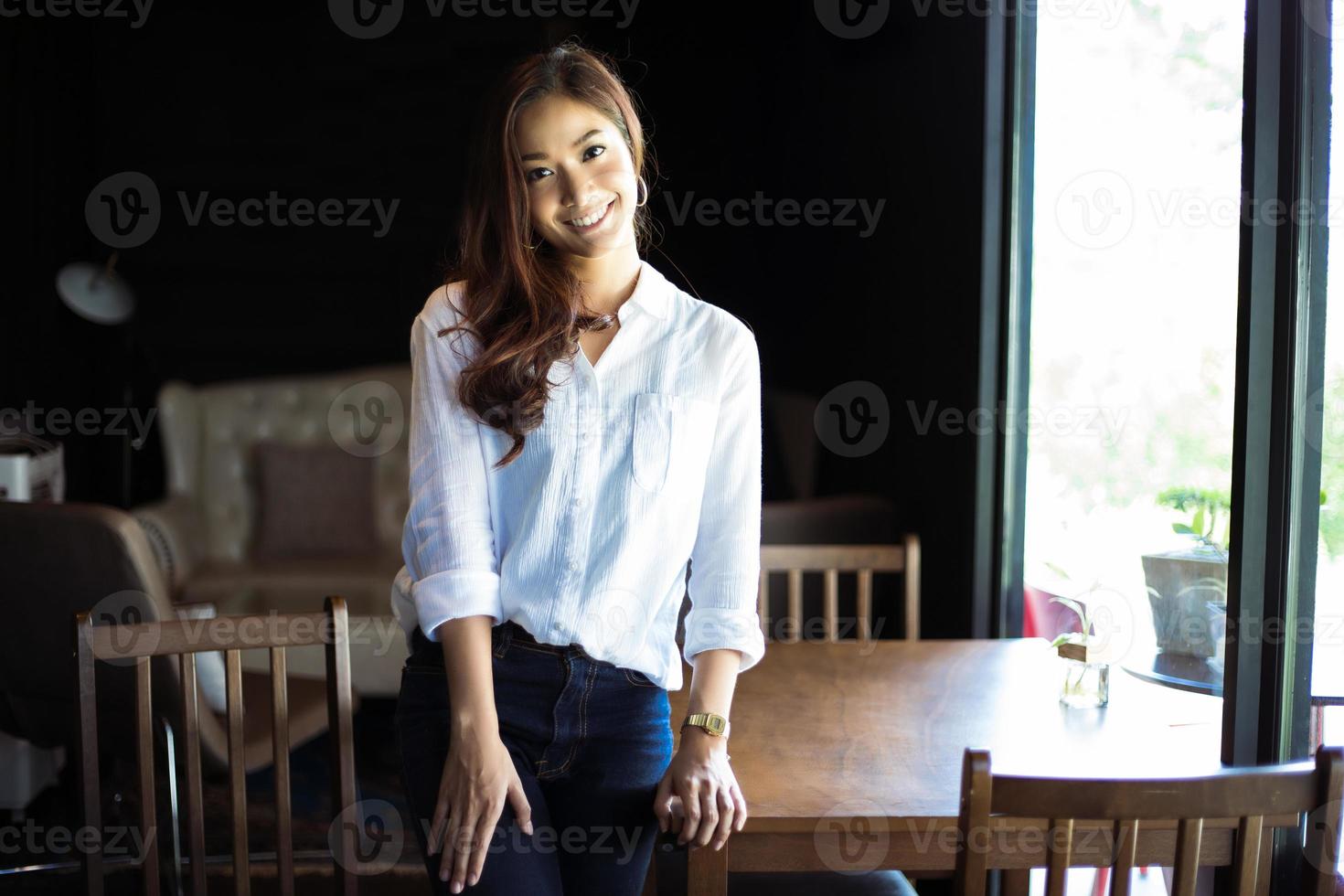 Asian women standing smiling and happy Relaxing in a coffee shop after working in a successful office. photo