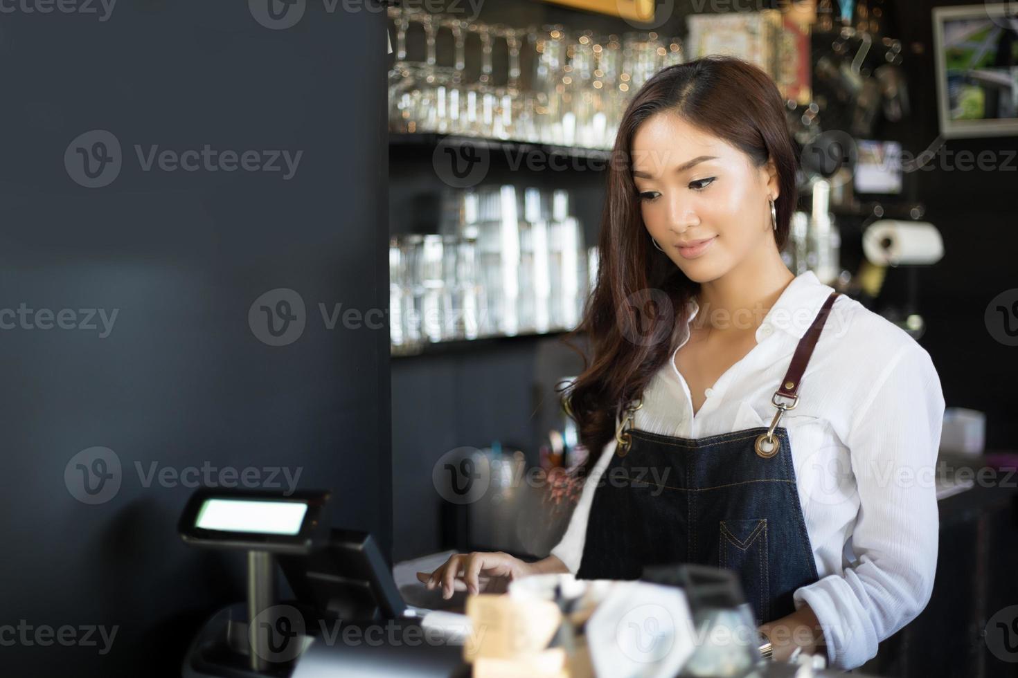 Las mujeres asiáticas barista sonriendo y usando la máquina de café en el mostrador de la cafetería - mujer trabajadora propietario de una pequeña empresa comida y bebida concepto de cafetería foto