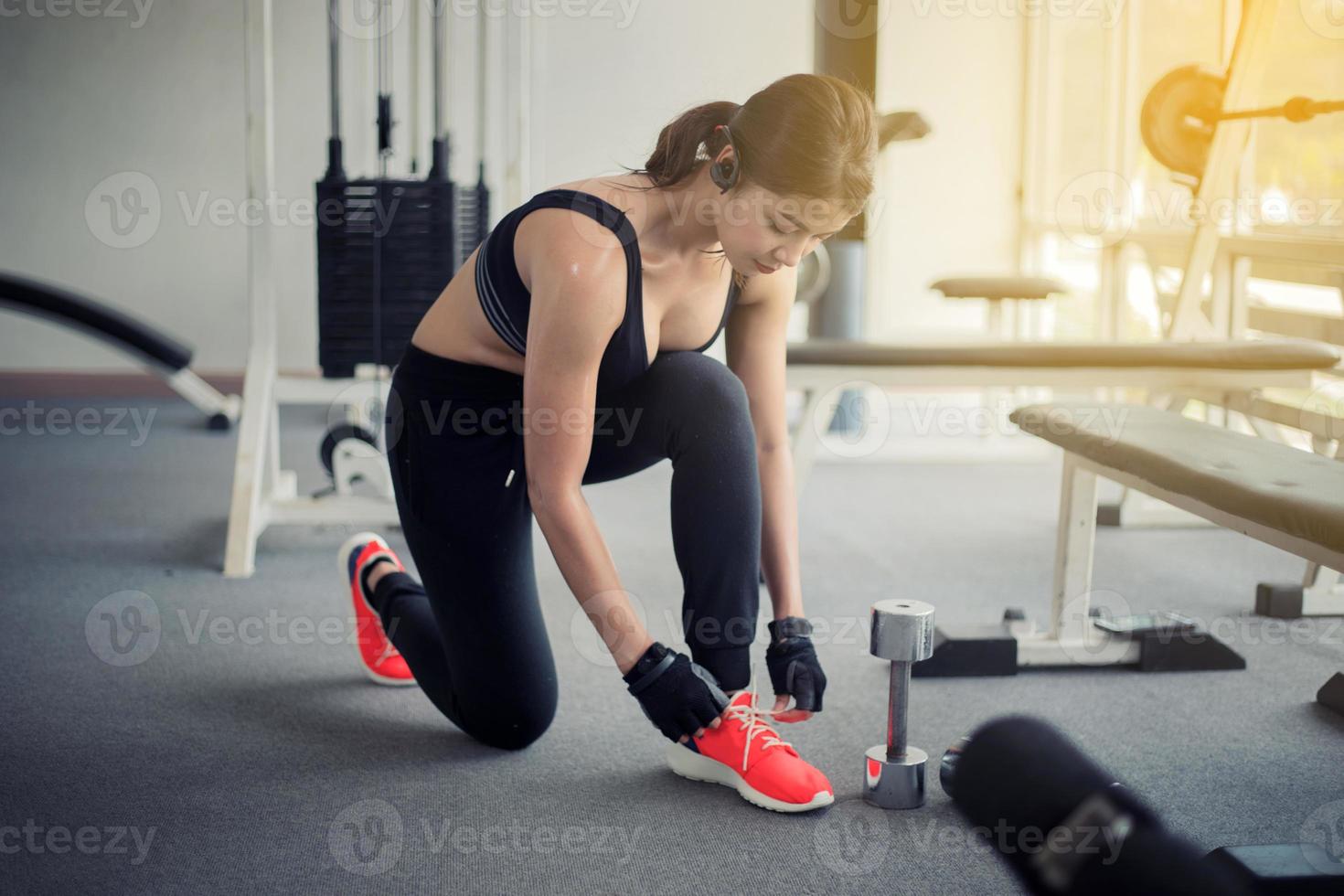 mujeres asiáticas atar cordones de zapatos. mujeres fitness preparándose para participar en el gimnasio foto