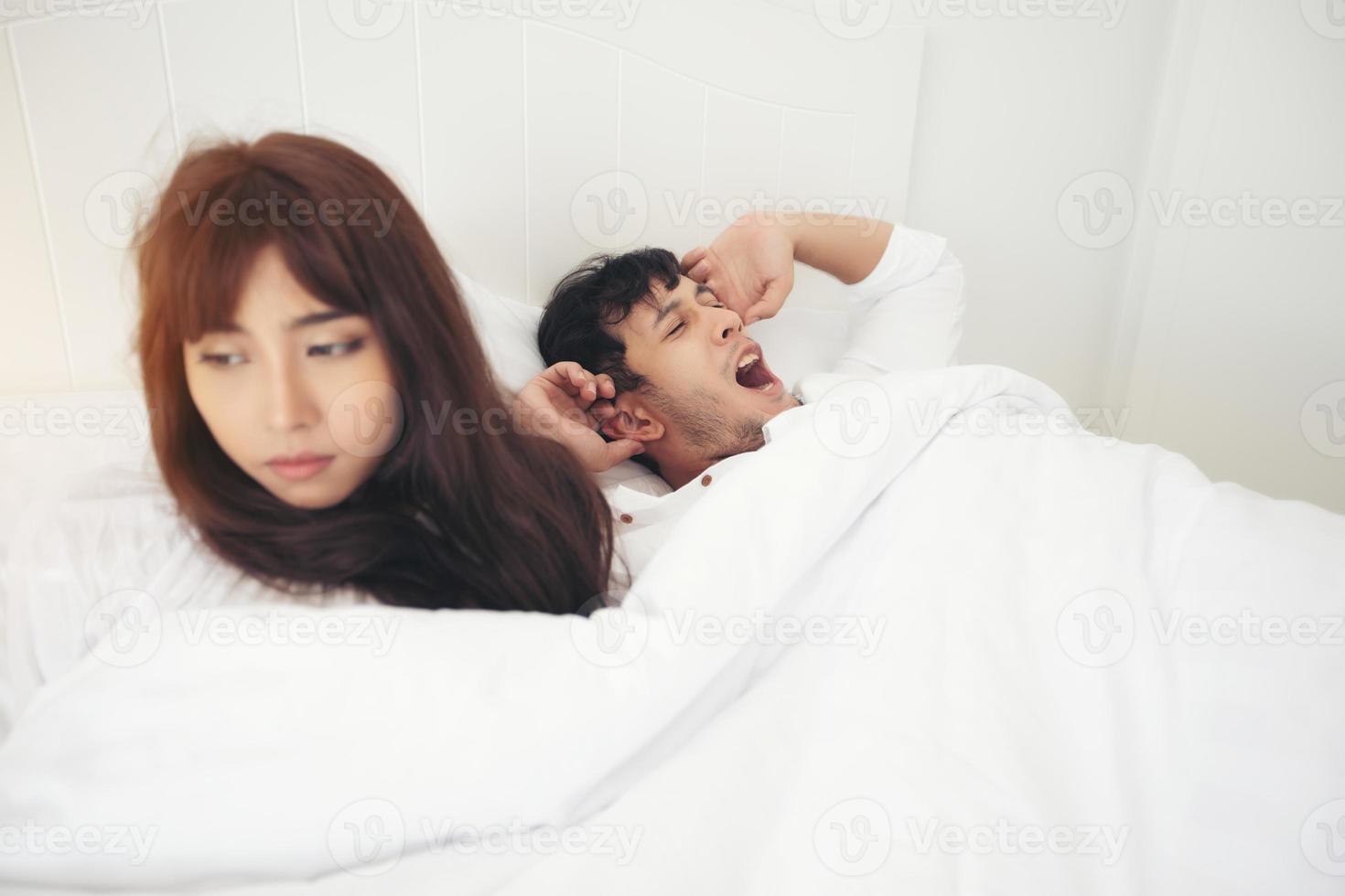 Amante de las parejas que se despierta en su cama completamente descansada y abre las cortinas por la mañana para que entre aire fresco. foto