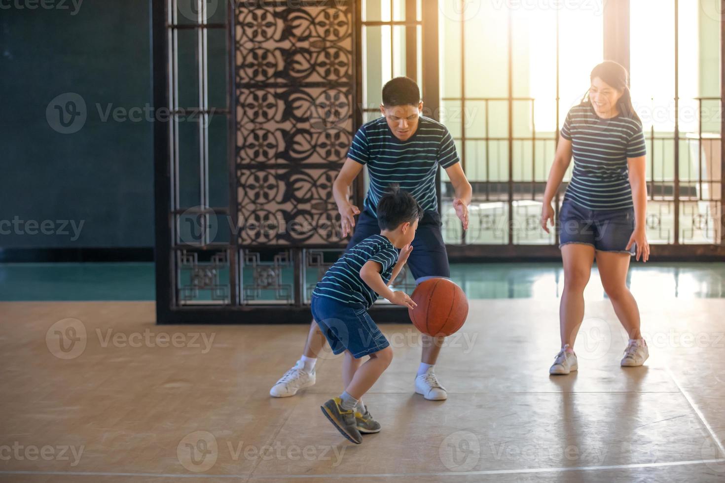 familia asiática jugando baloncesto juntos. familia feliz pasando tiempo libre juntos en vacaciones foto