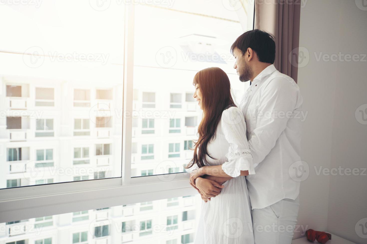 Amante de las parejas acostado en la cama estilo de vida de felicidad y niña sonriente relajándose en la cama blanca foto