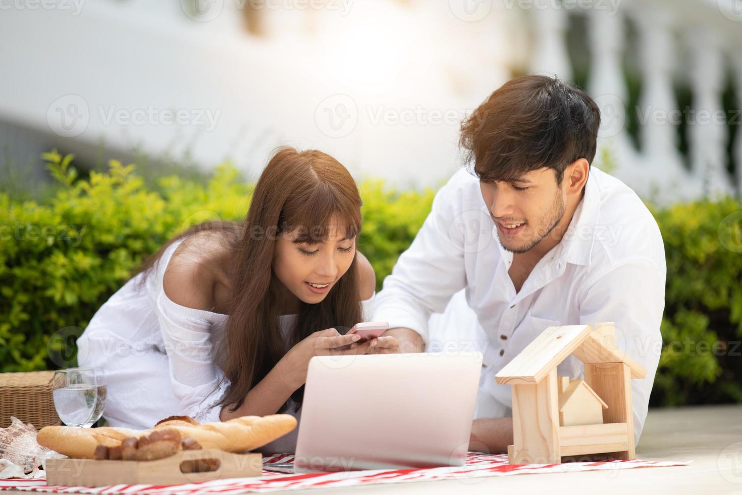 Happy Romantic Couples lover talking and drinking wine while having a picnic at home photo