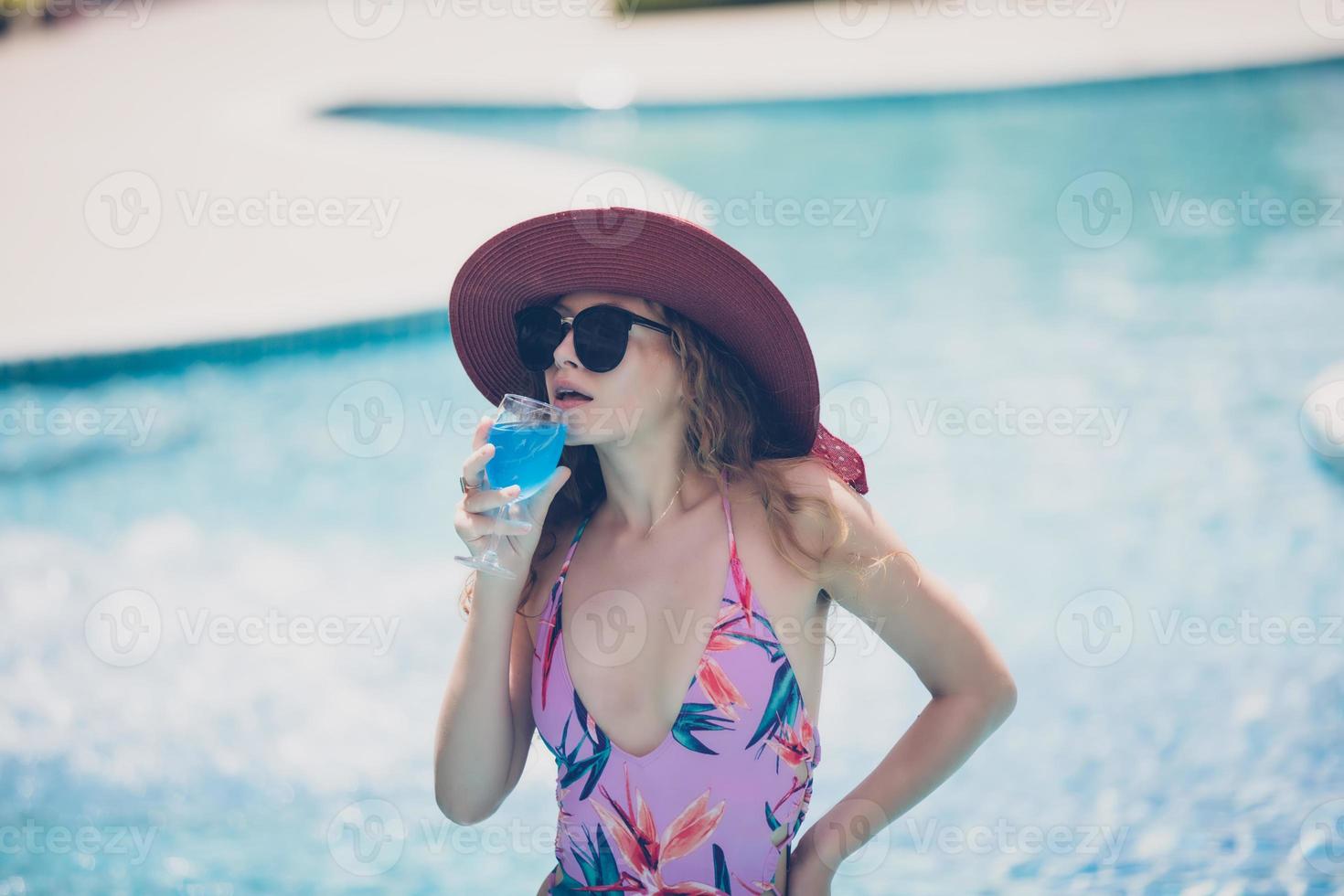Women wear bikinis and drinking cocktails in the hot summer at the swimming pool. photo