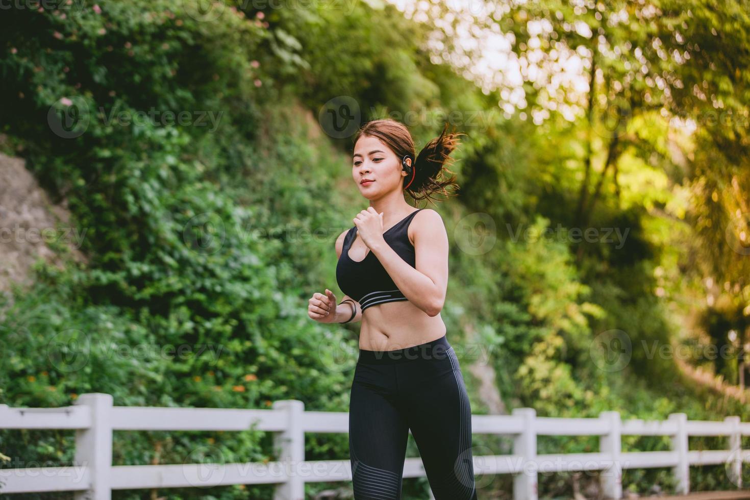 Mujeres asiáticas corriendo y trotando durante el exterior en la carretera en el parque foto