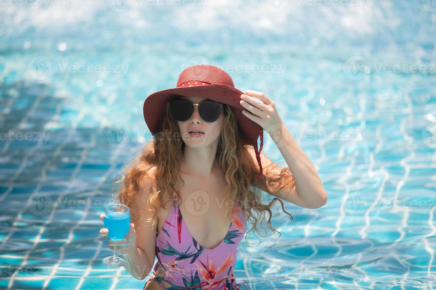 las mujeres usan bikinis y beben cócteles en el caluroso verano en la piscina. foto