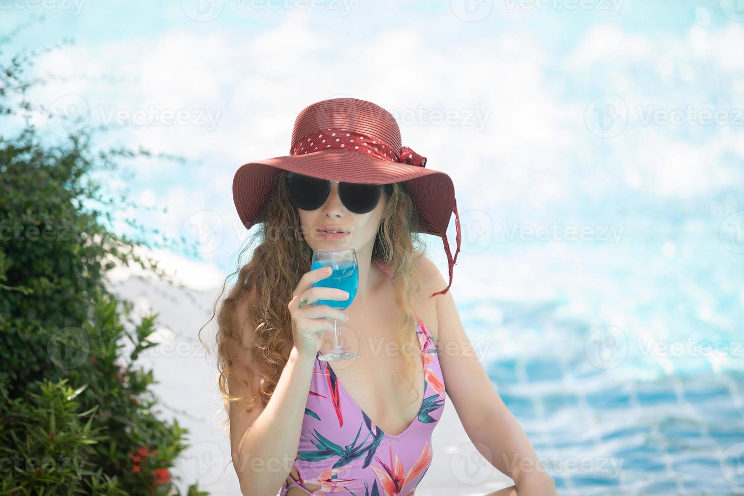 las mujeres usan bikinis y beben cócteles en el caluroso verano en la piscina. foto