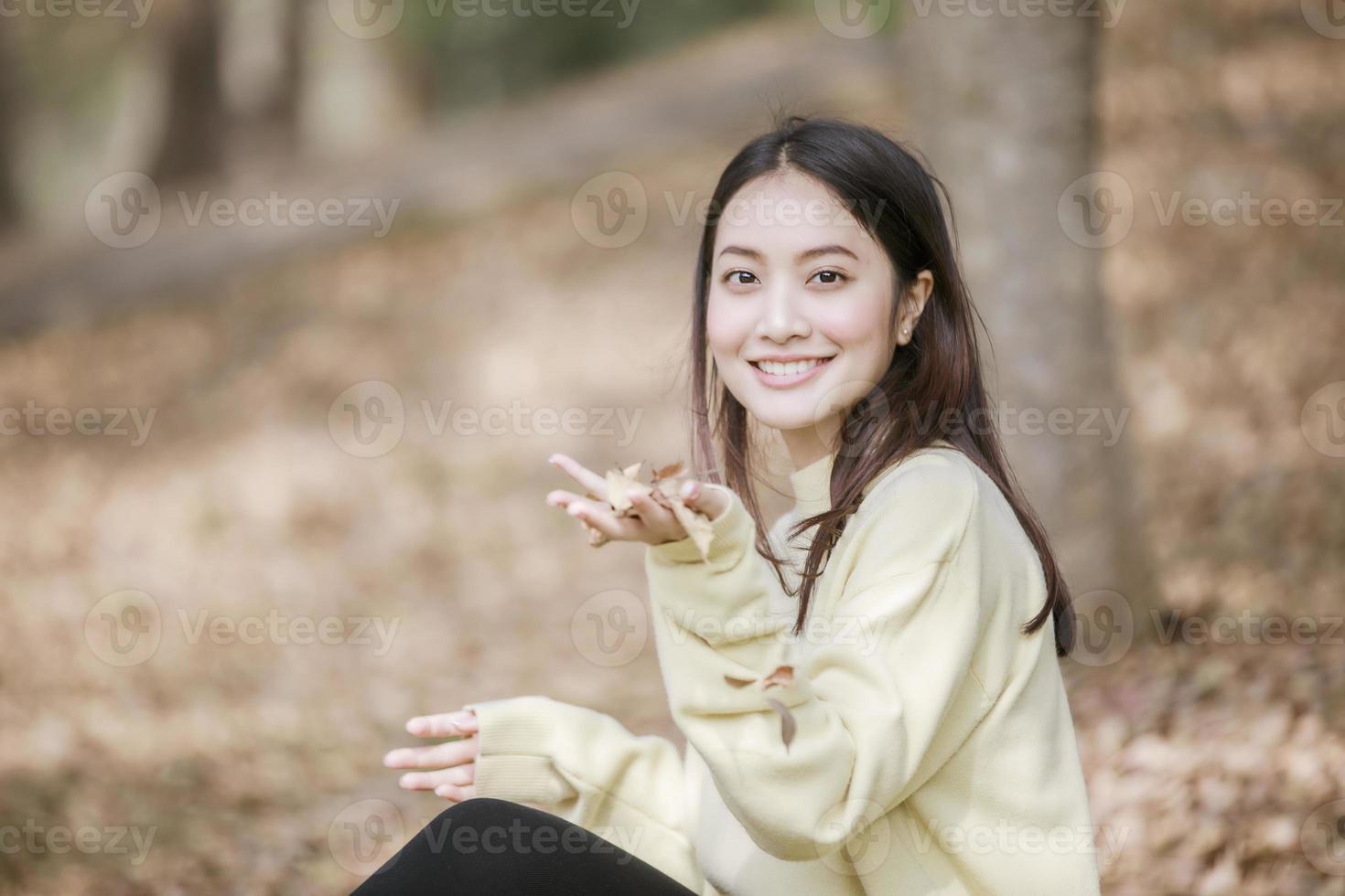 Hermosa mujer asiática sonriente niña feliz y vistiendo ropa abrigada retrato de invierno y otoño al aire libre en el parque foto