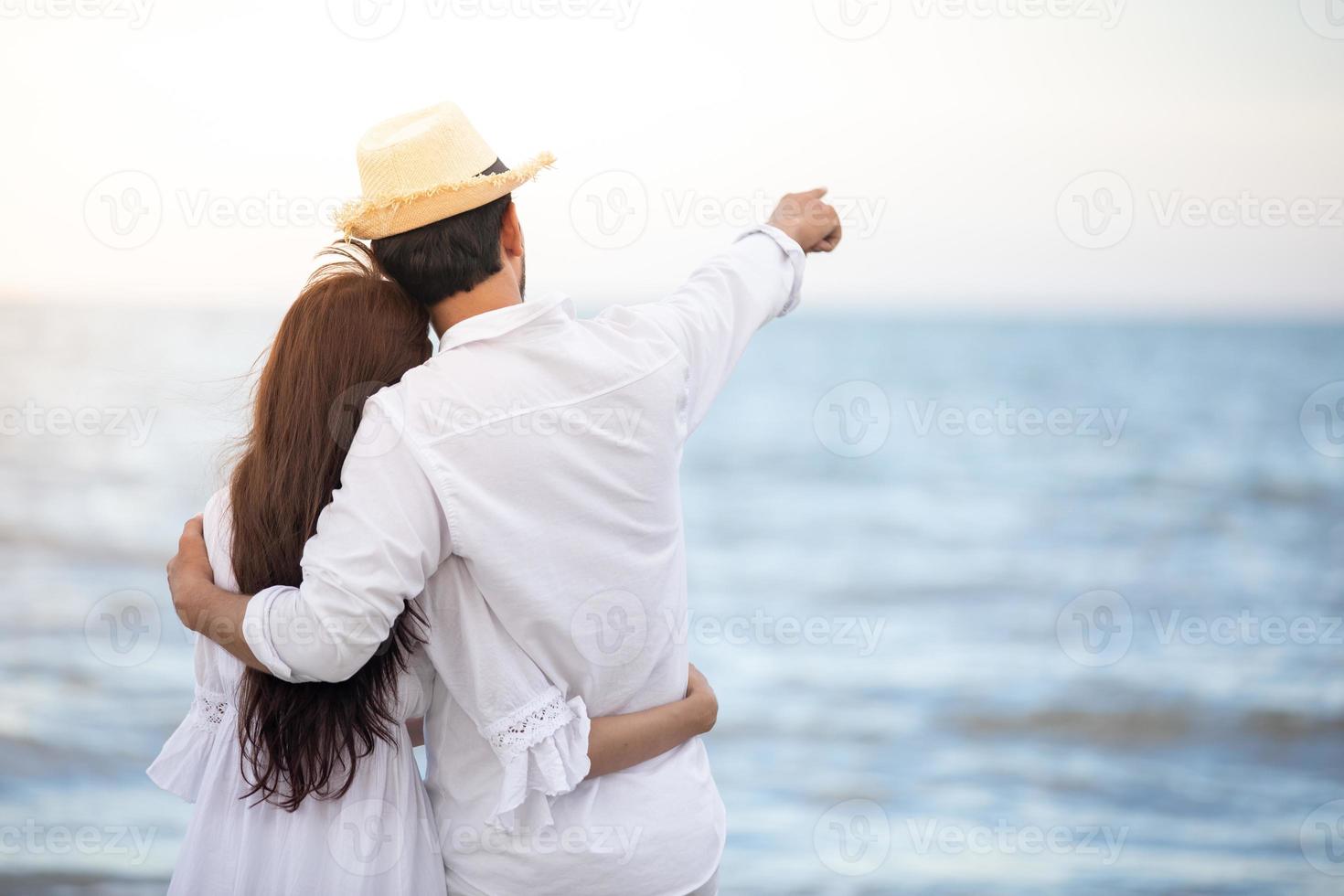 Feliz pareja romántica amante tomados de la mano juntos caminando por la playa foto