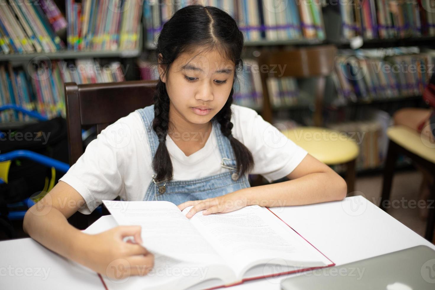 Asian students reading books in the library. photo