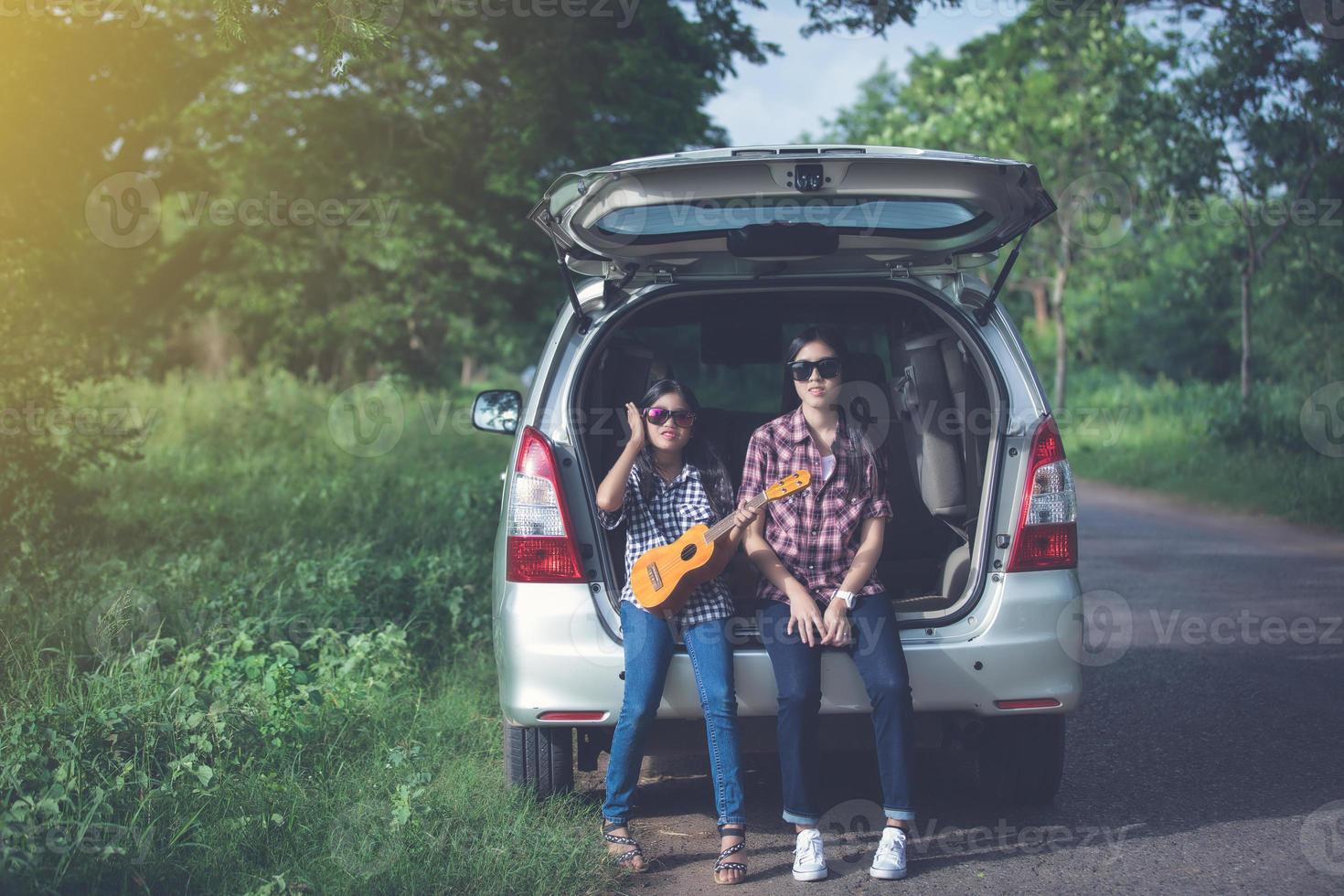 Happy little girl  with asian family sitting in the car for enjoying road trip and summer vacation in camper van photo