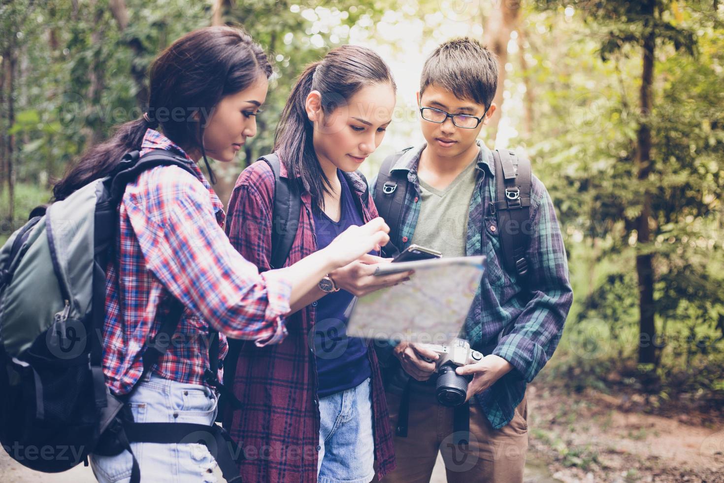 Asian Group of young people Hiking with friends backpacks walking together and looking map and taking photo camera by the road and looking happy ,Relax time on holiday concept travel