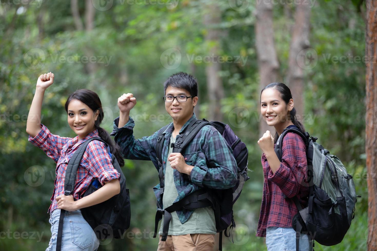 Asian Group of young people Hiking with friends backpacks walking together and looking map and taking photo camera by the road and looking happy ,Relax time on holiday concept travel
