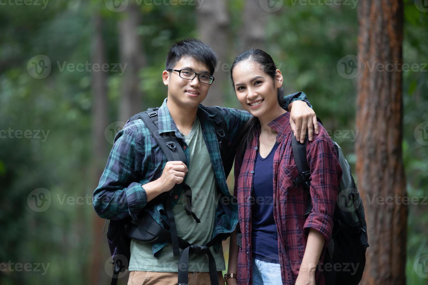 Asian Group of young people Hiking with friends backpacks walking together and looking map and taking photo camera by the road and looking happy ,Relax time on holiday concept travel