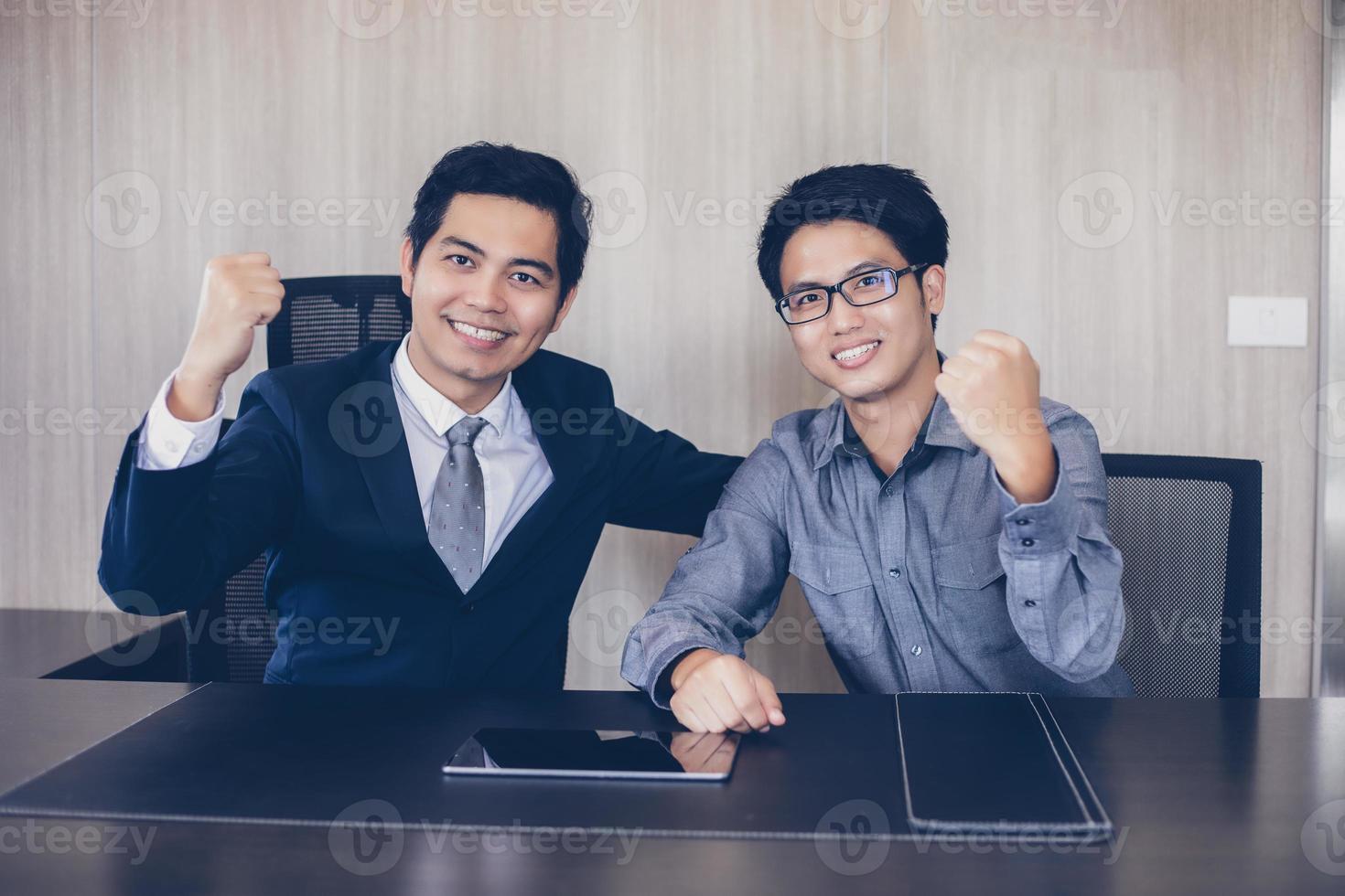 éxito de los empresarios asiáticos y concepto ganador: equipo feliz con las manos levantadas celebrando el avance y los logros foto