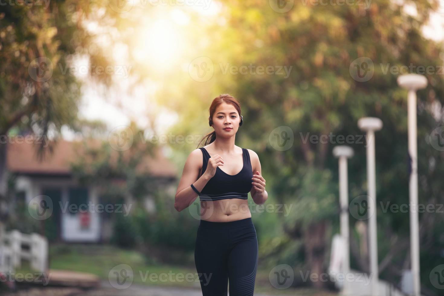 Running woman. Female runner jogging during outdoor  on road .Young mixed race girl jogging photo