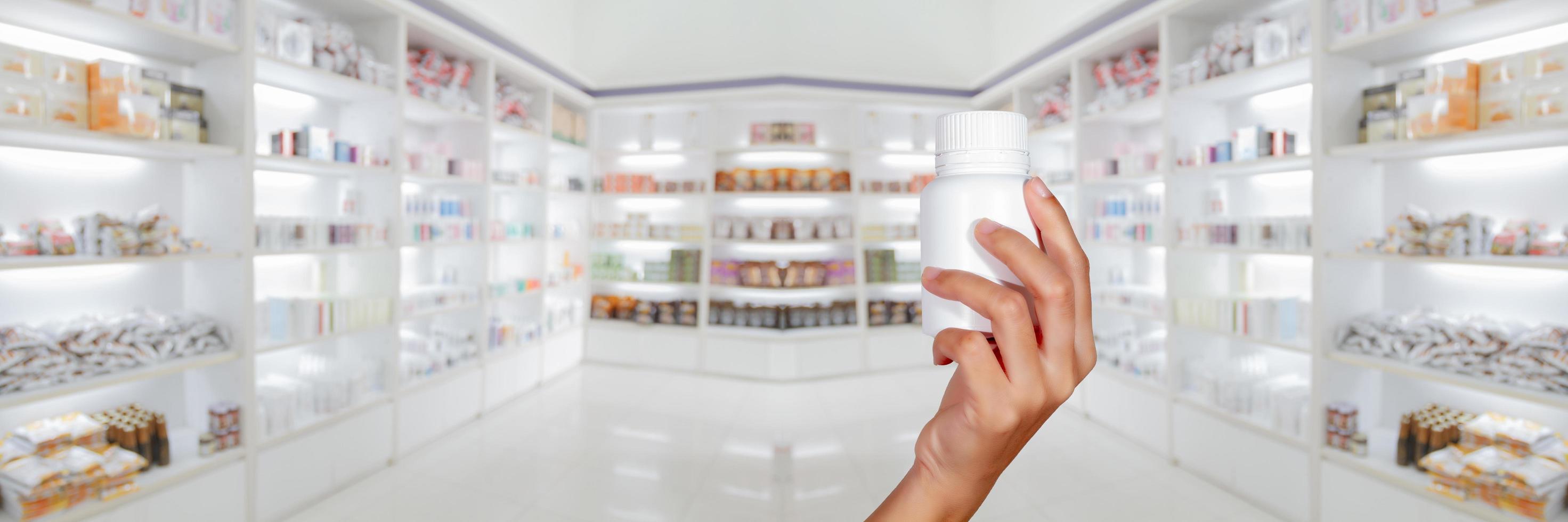 hand of doctor holding medicine bottle on medicine cabinet and store medicine and pharmacy drugstore photo