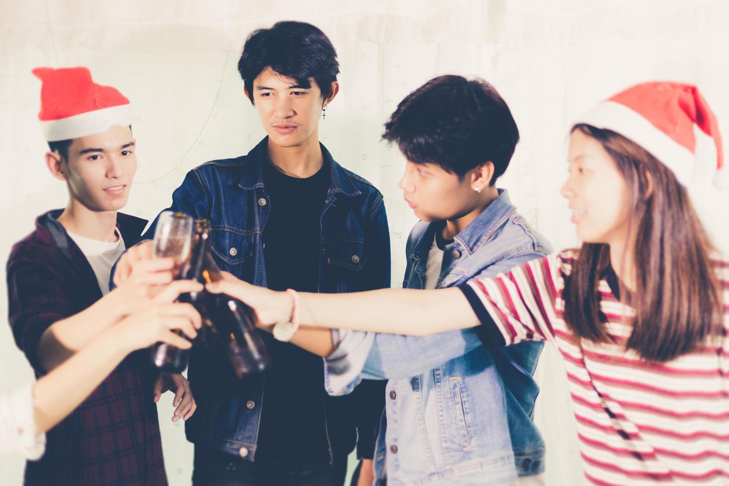 Grupo asiático de amigos de fiesta con bebidas alcohólicas de cerveza y jóvenes disfrutando en un bar brindando cócteles enfoque suave. foto