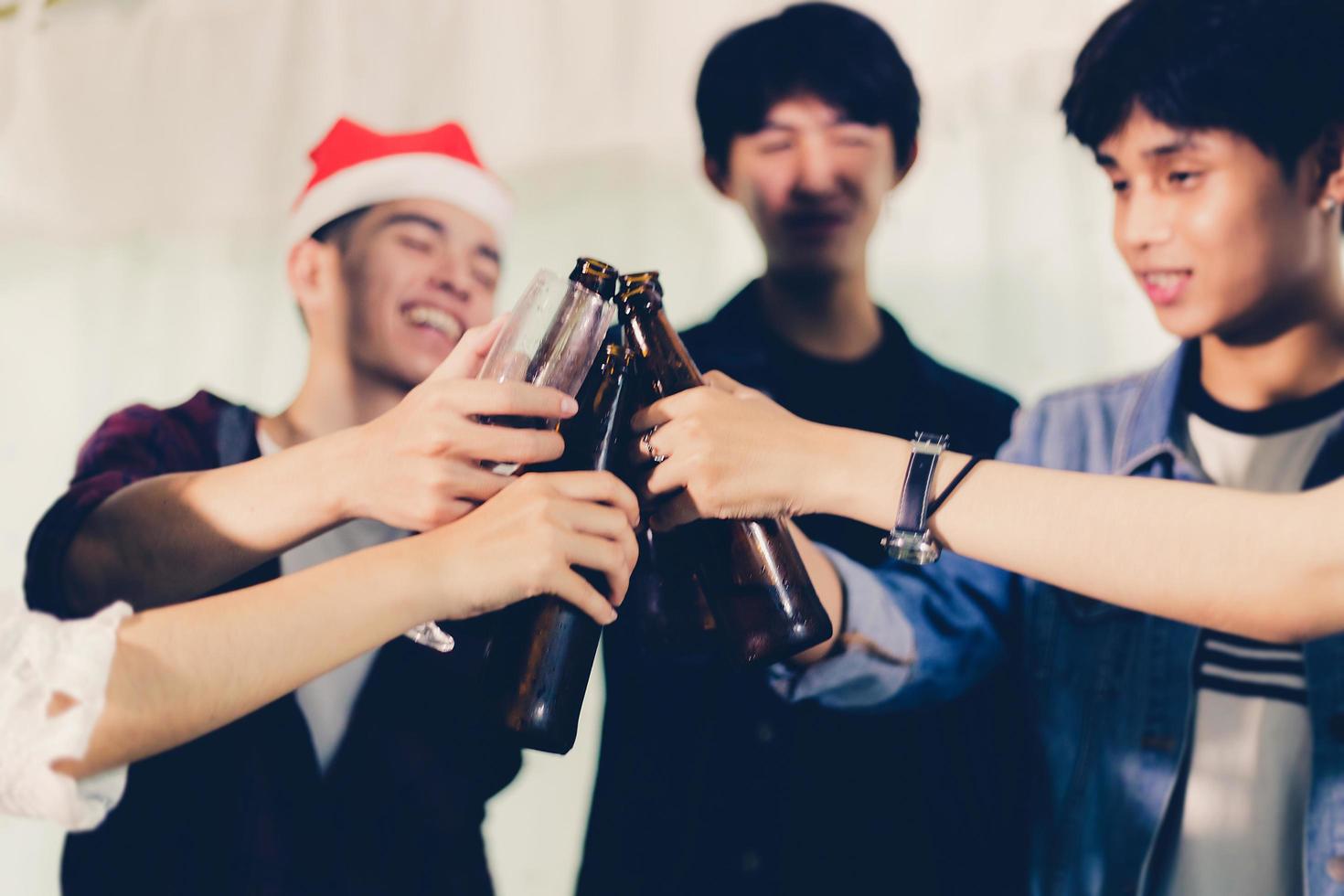 Grupo asiático de amigos de fiesta con bebidas alcohólicas de cerveza y jóvenes disfrutando en un bar brindando cócteles enfoque suave. foto