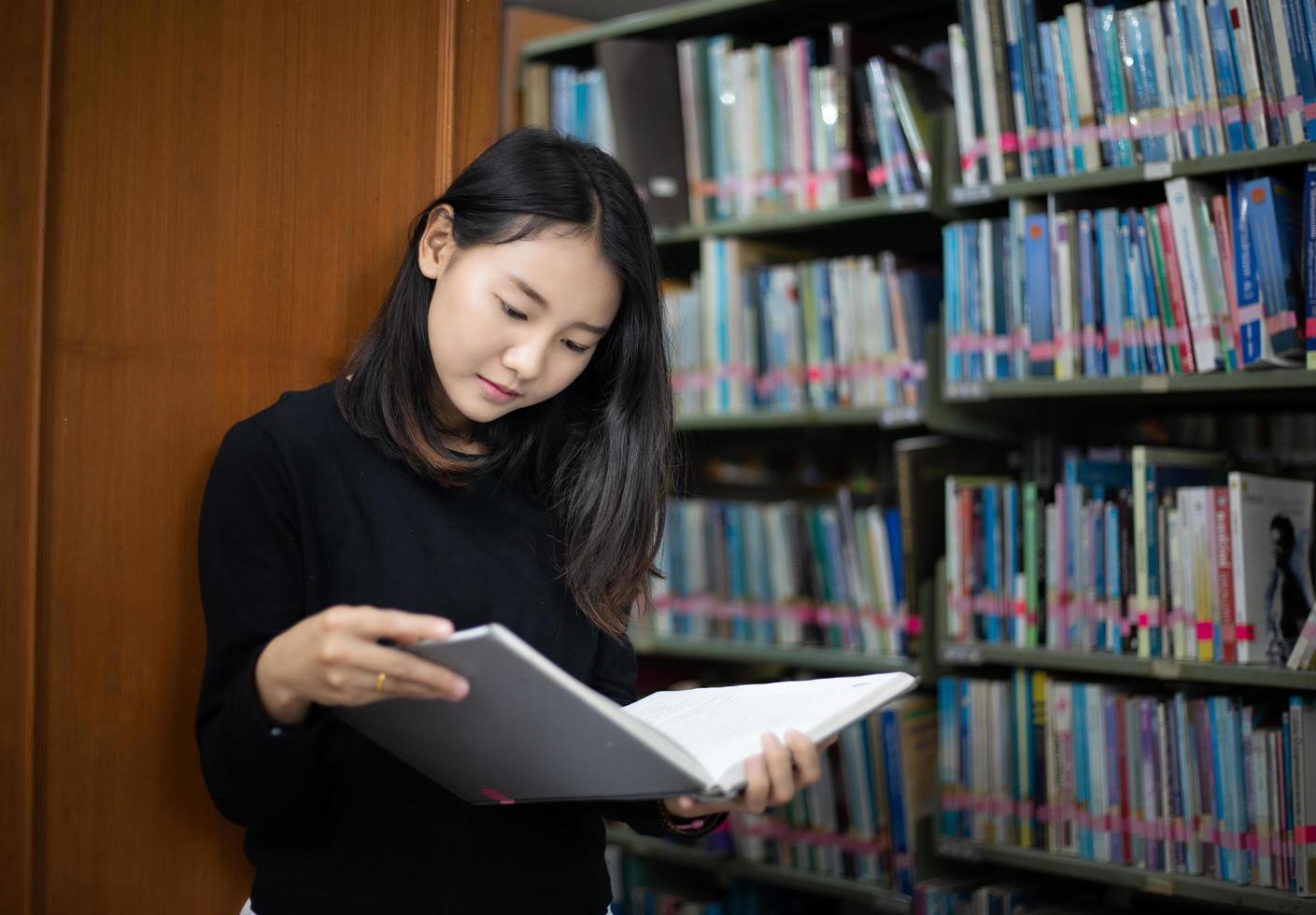 estudiantes asiáticos leyendo libros en la biblioteca. foto