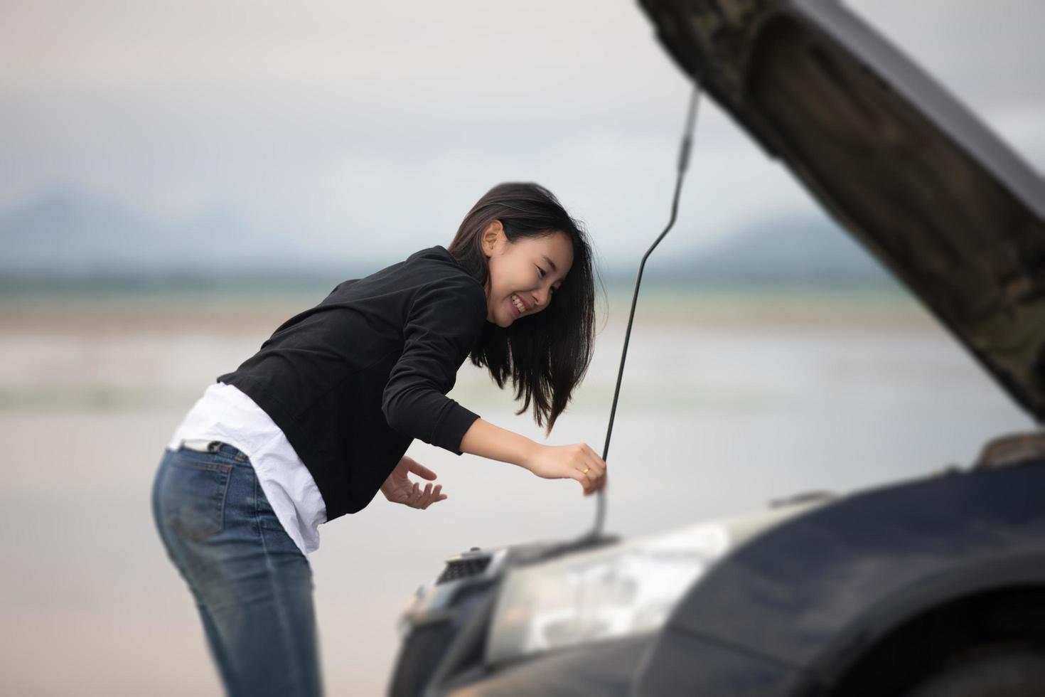 Asian woman using mobile phone while looking and Stressed man sitting after a car breakdown on street photo