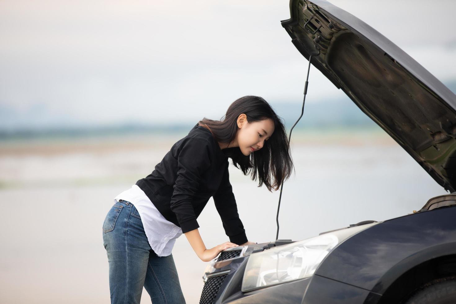 Stressed women  after a car breakdown with Red triangle of a car on the road photo