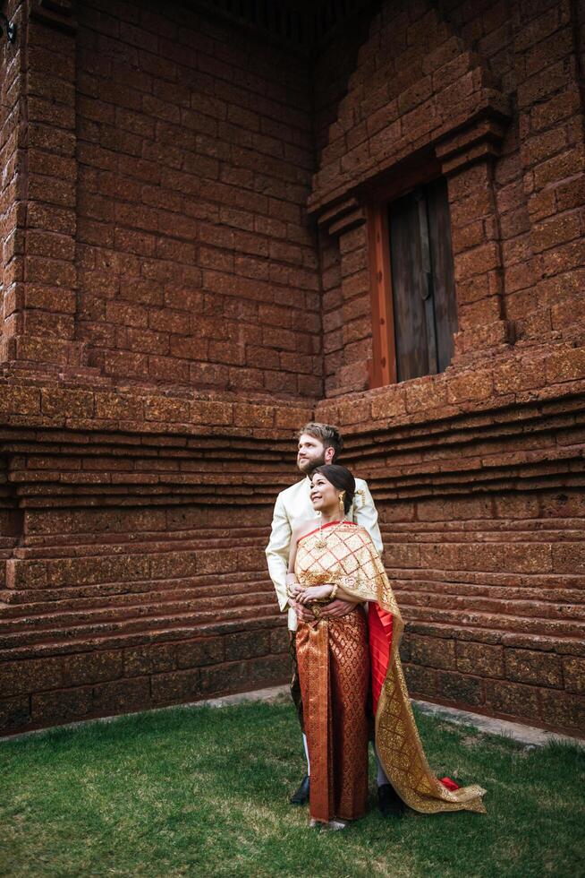 Asian bride and Caucasian groom have romantic time with Thailand dress photo